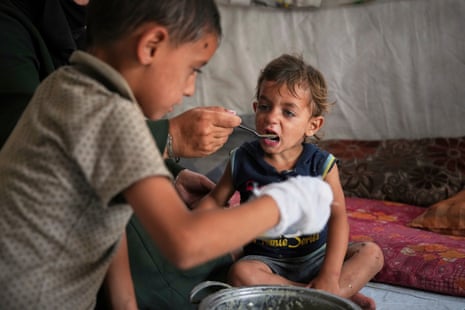A little boy is fed with food from a community kitchen in Khan Younis, in the southern Gaza Strip.