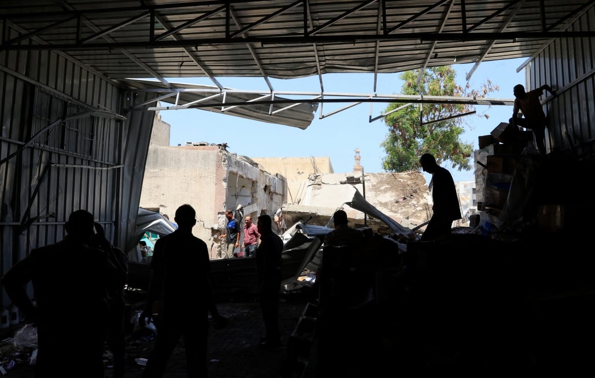 Palestinian staff members inspect the medicine warehouse in Nasser Hospital after an Israeli strike.
