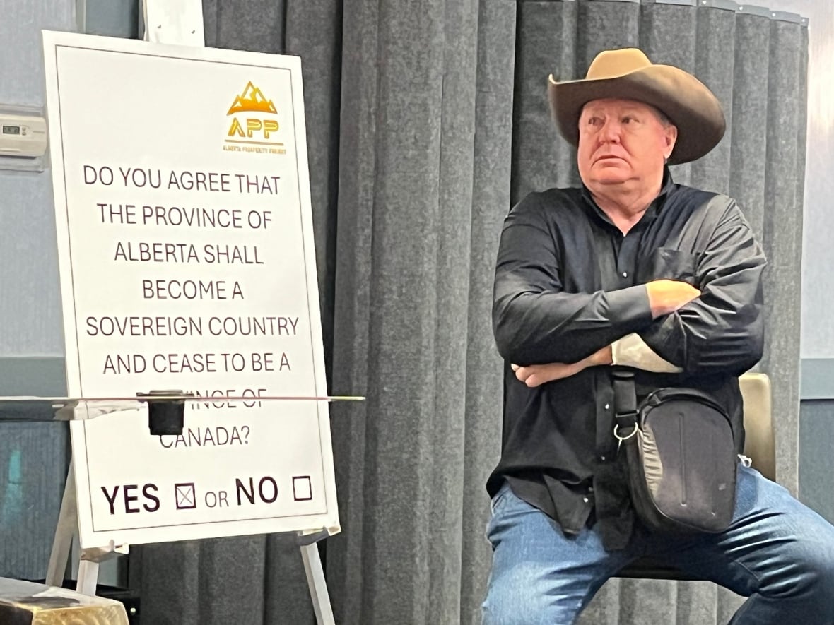 A man in a cowboy hat sits next to a referendum question.