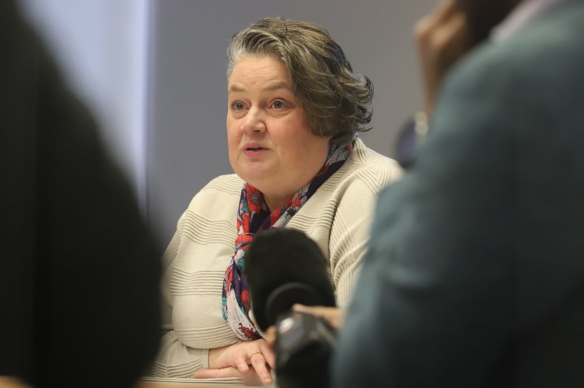 A woman speaks to reporters.
