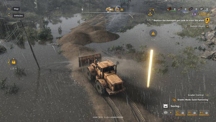 A bulldozer flattens out some sand to prepare a road over a flooded area.