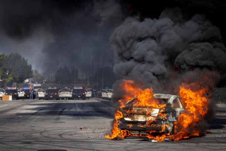 A car burns on Atlantic Boulevard during a standoff by protesters and law enforcement, following multiple detentions by Immigration and Customs Enforcement (ICE), in the Los Angeles County city of Paramount, California, U.S., June 7, 2025.