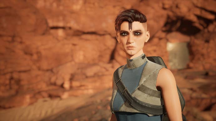 The player character faces the camera with short hair against a background of red rock.