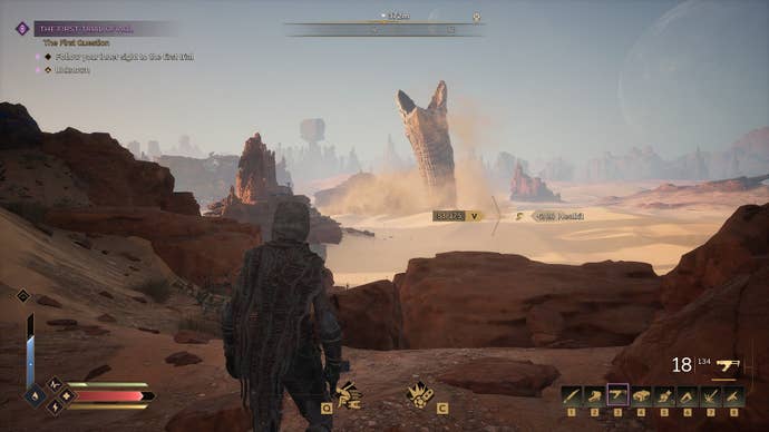 A sandworm rises in the distance as the player looks on.
