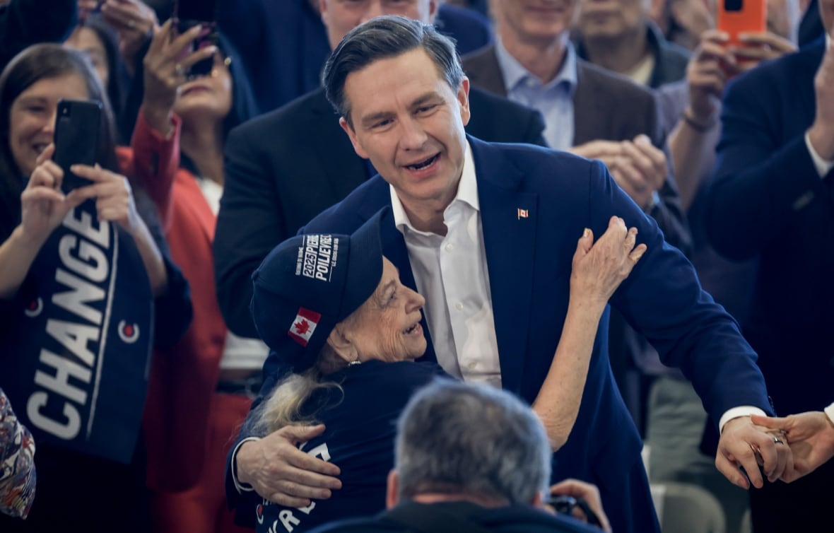 A man and his elderly mother embrace at a political rally.