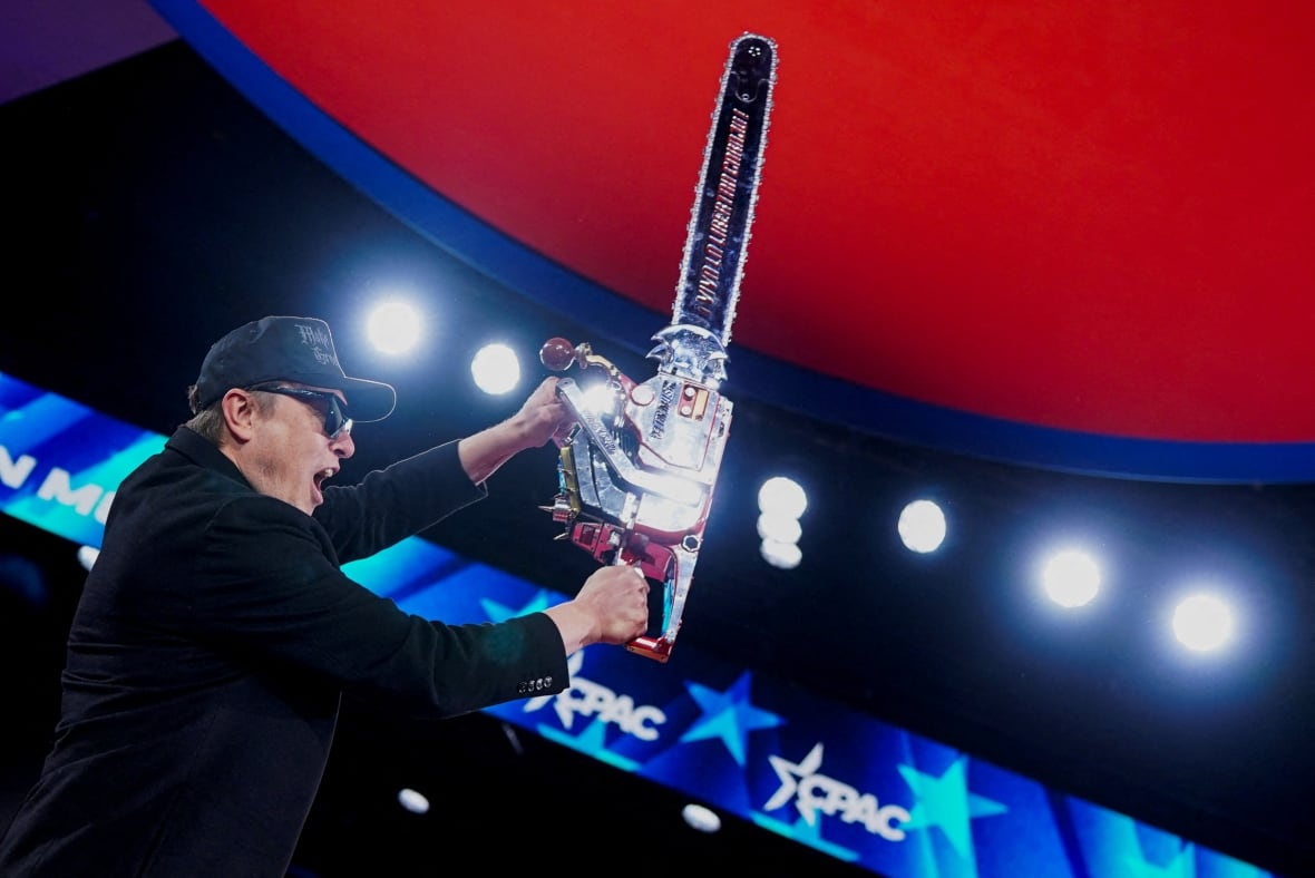 A man holds a chainsaw.