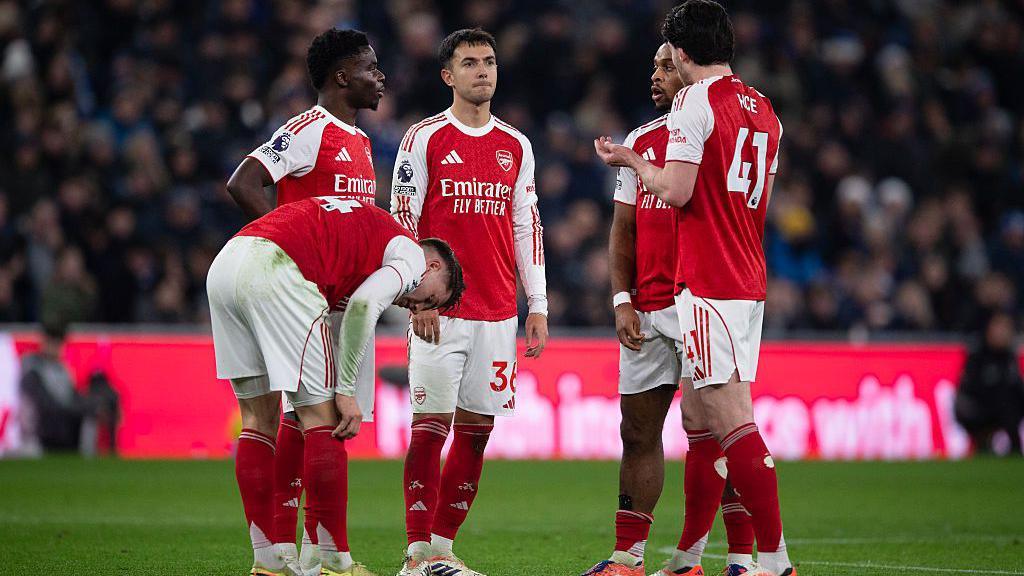 Arsenal players talking on the pitch