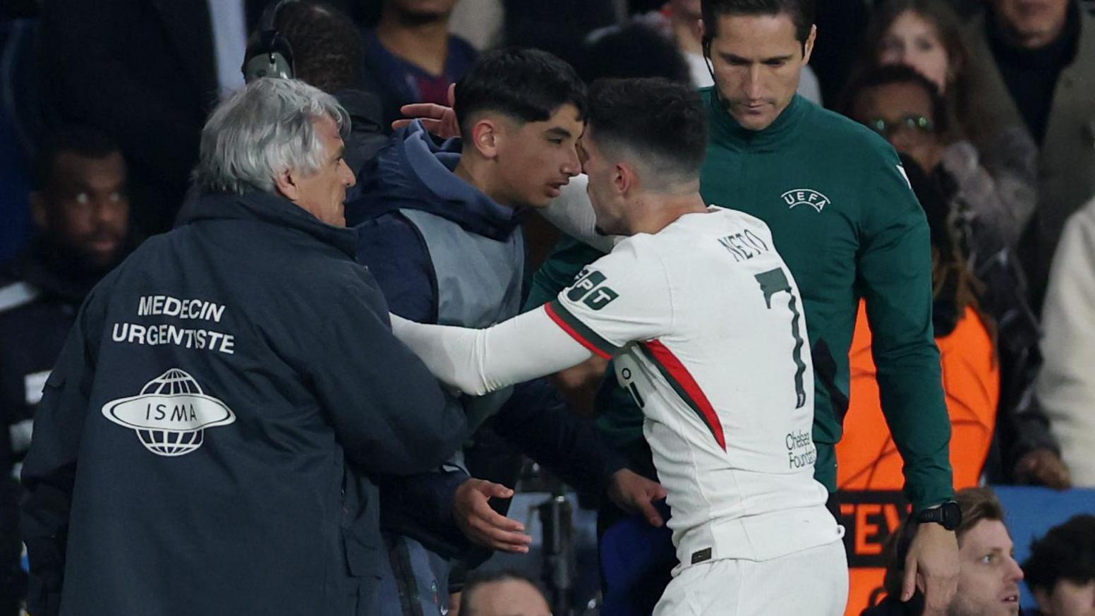 Chelsea's Pedro Neto embraces a PSG ball boy in the aftermath of shoving him during their Champions League match