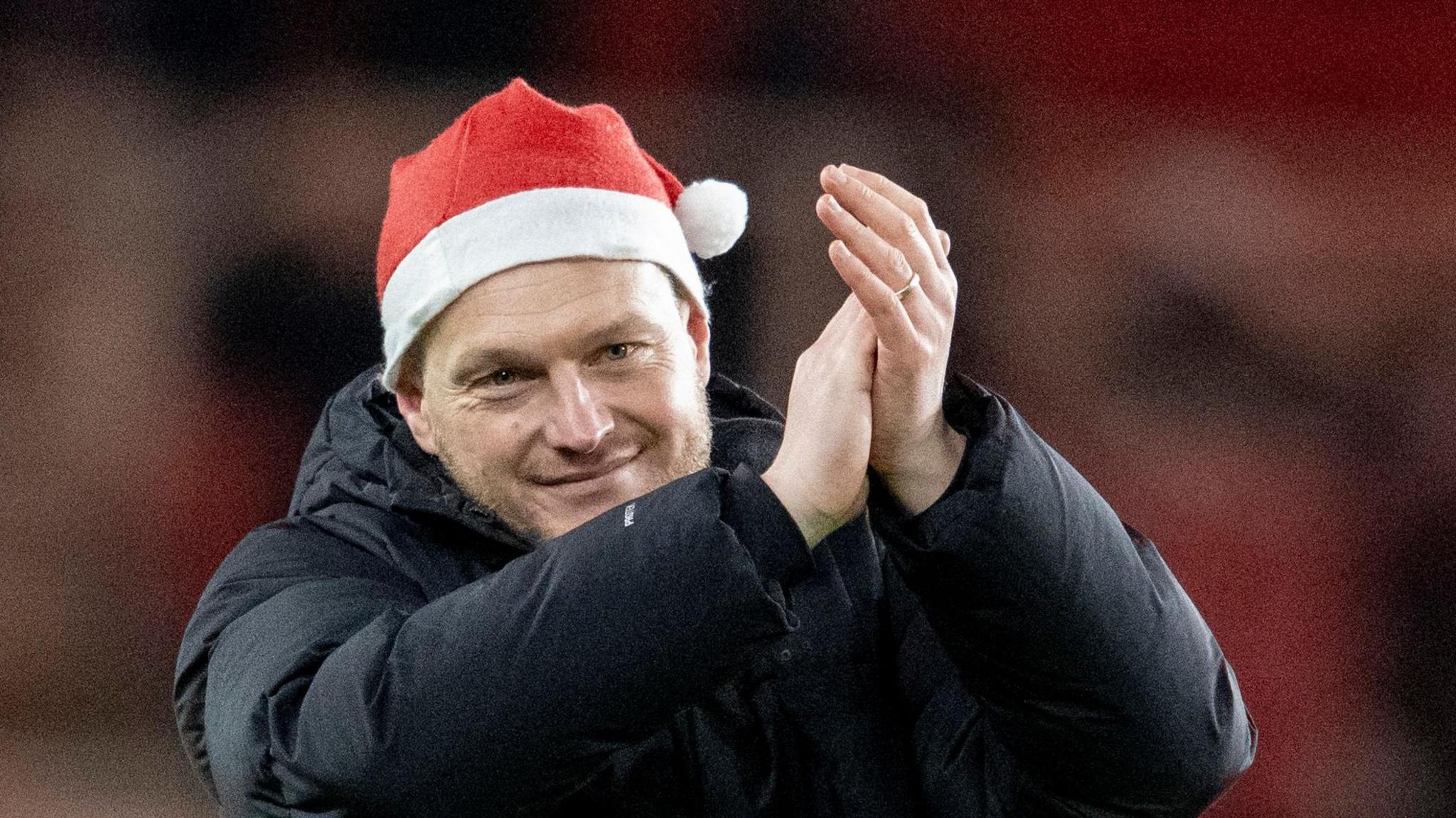 Kim Hellberg claps Middlesbrough fans after a game wearing a red Santa hat