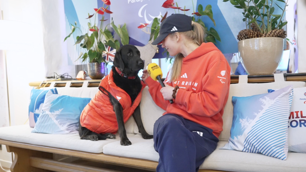 Pickle and Hester Poole sat on a sofa with a BBC Sport microphone in ParalympicsGB House.