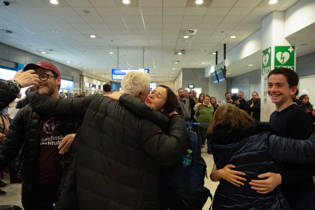 Air travelers stranded by the Iran conflict are greeted in Athens, Greece, after arriving on a charter flight from Dubai on Saturday.