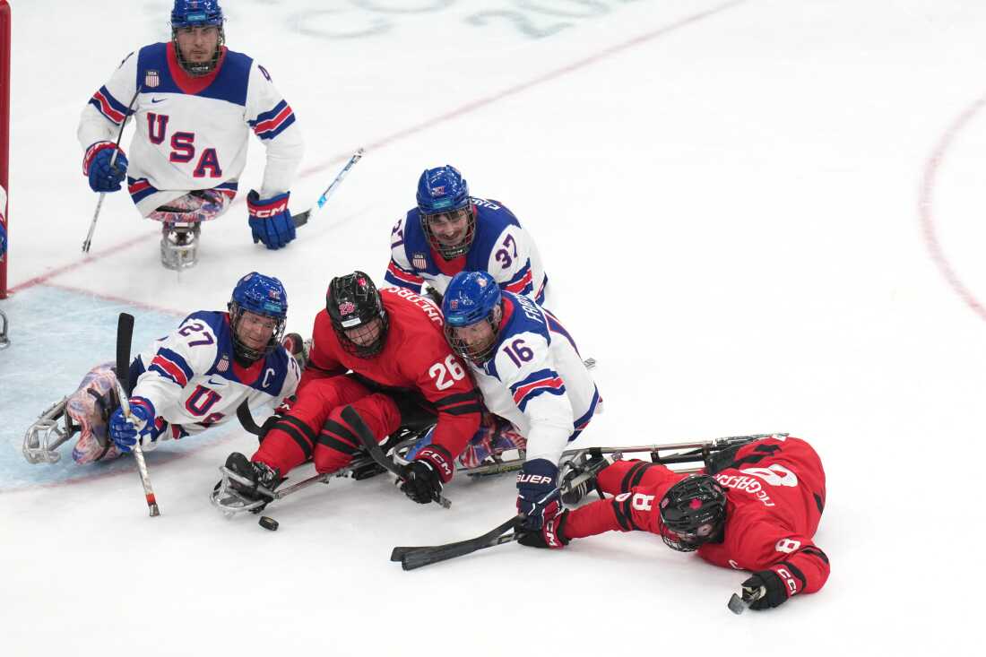 Team USA's Declan Farmer (C) fights for the puck during the gold-medal match against Canada.