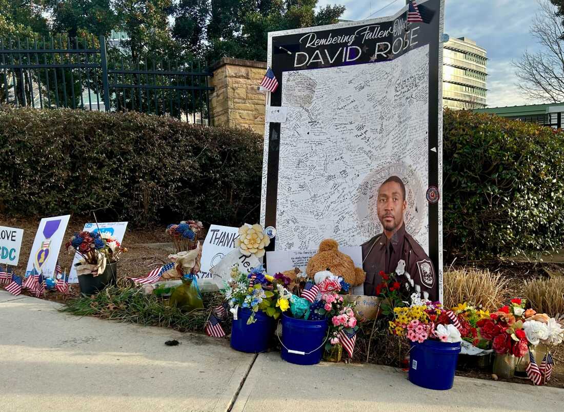 People continue to leave flowers and notes at a memorial for DeKalb County Officer David Rose, who was killed in the Aug. 8 shooting outside the CDC headquarters in Atlanta.