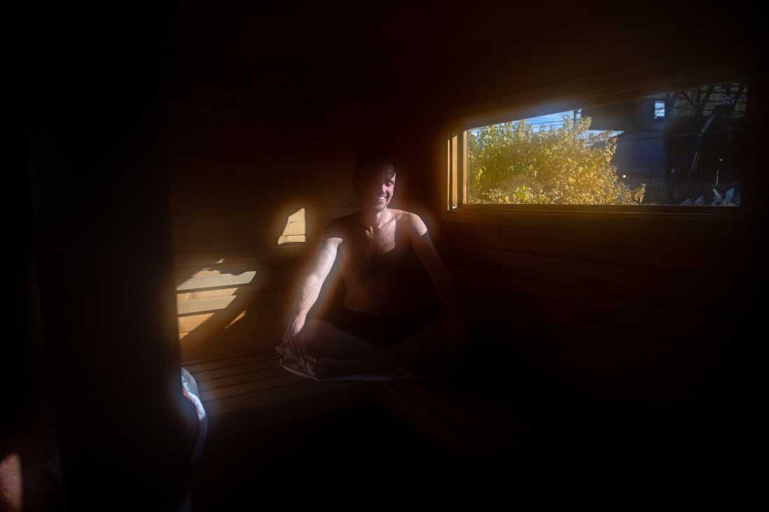 Michael Calcagno, of Seattle, sits inside a mobile sauna, during the Seattle Sauna Festival. Sauna enthusiasts often report a mental health boost after time spent soaking in the hot air.